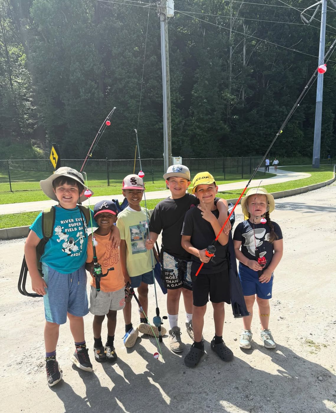 Campers holding fishing rods during Summer 2026