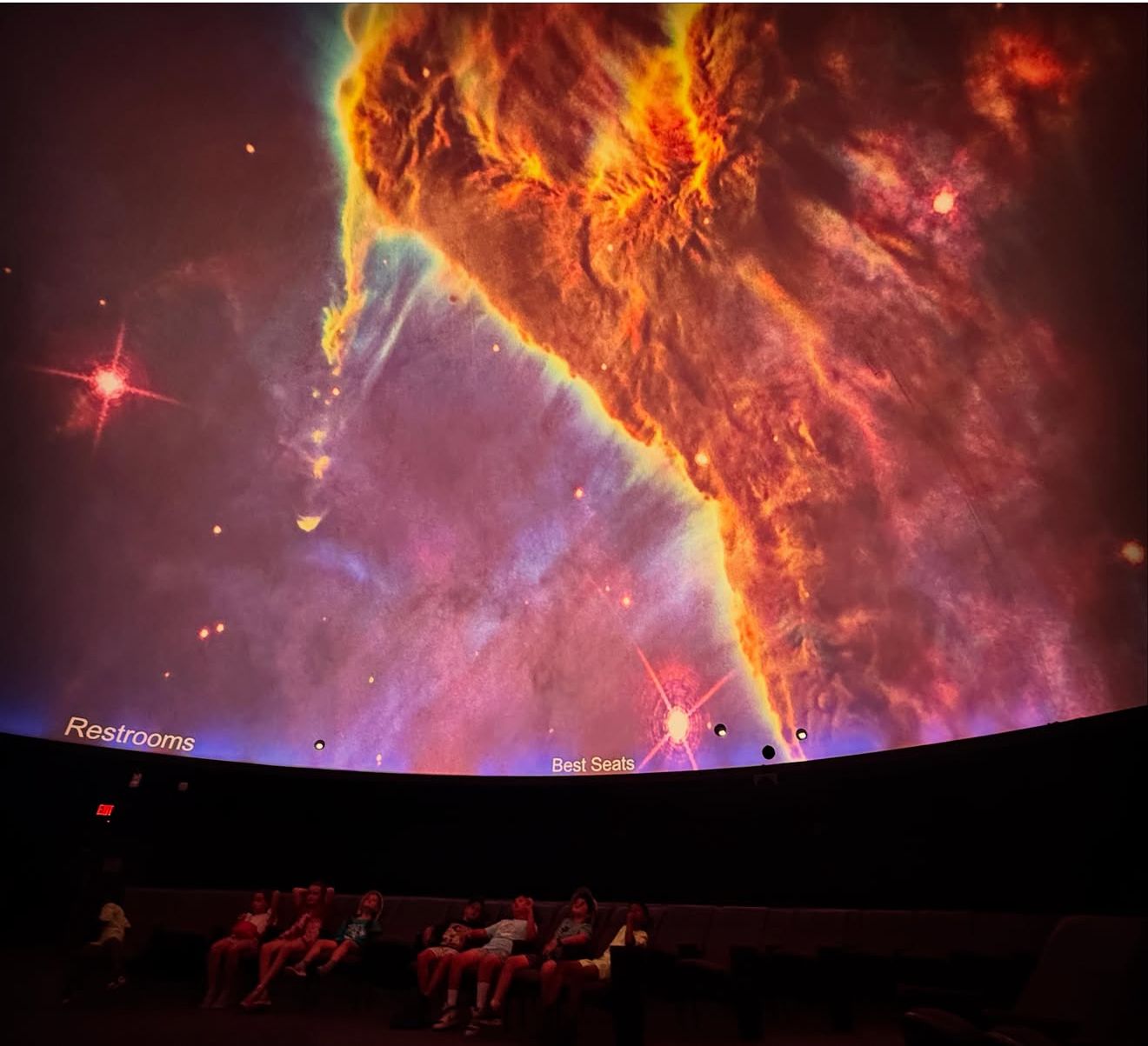 Campers watching a nebula on the planetarium dome