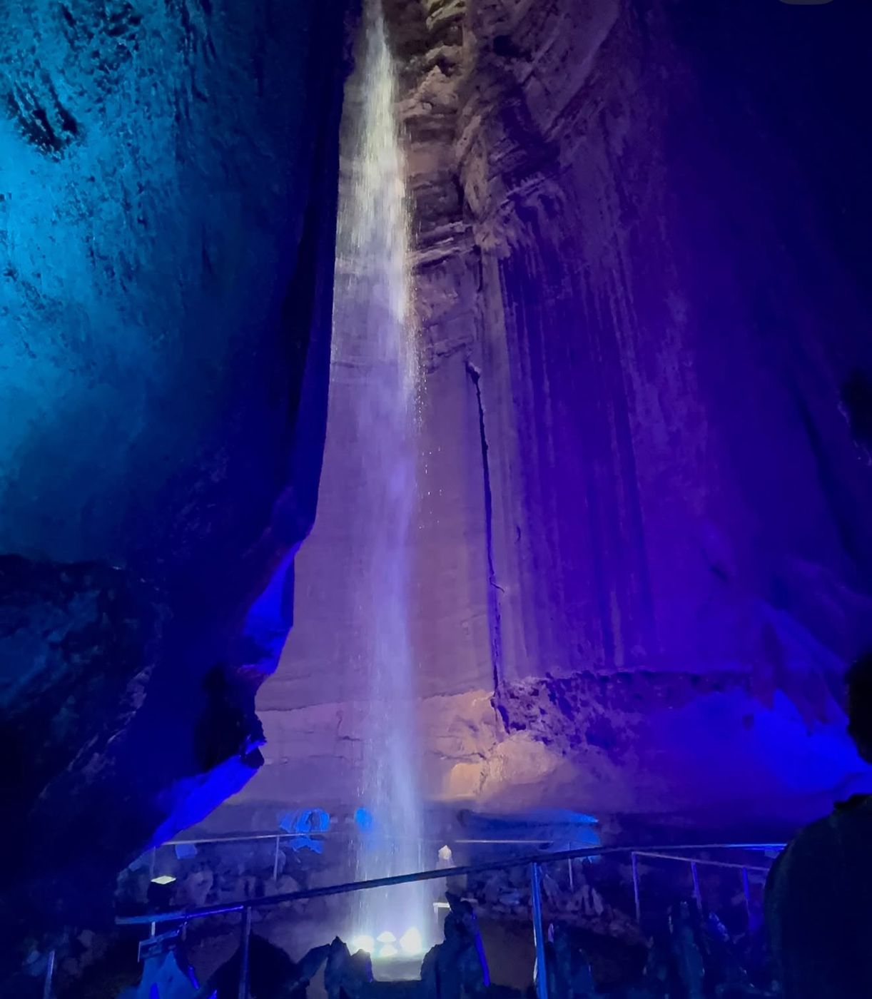 Underground waterfall lit in blue and purple