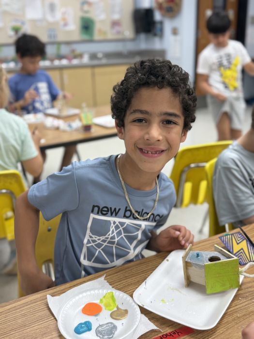 Student with a painted birdhouse