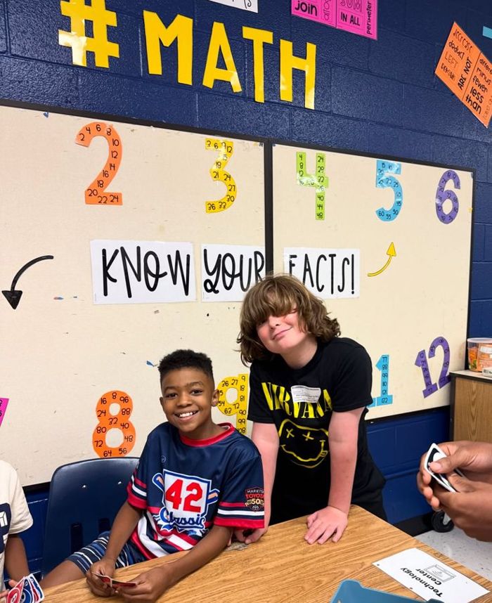Two students at the math facts wall
