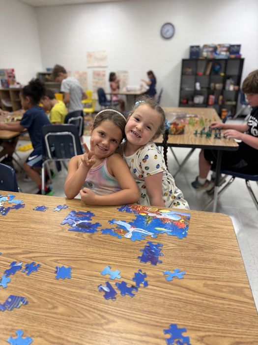 Two students smiling over a puzzle