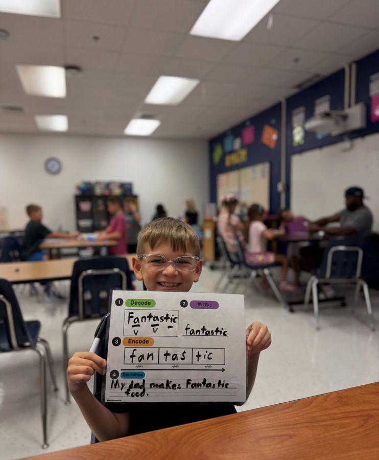 Student showing a decode, write and sentence reading exercise