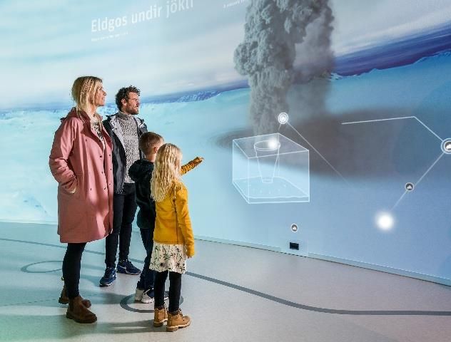 Family exploring a volcano exhibit at Perlan museum
